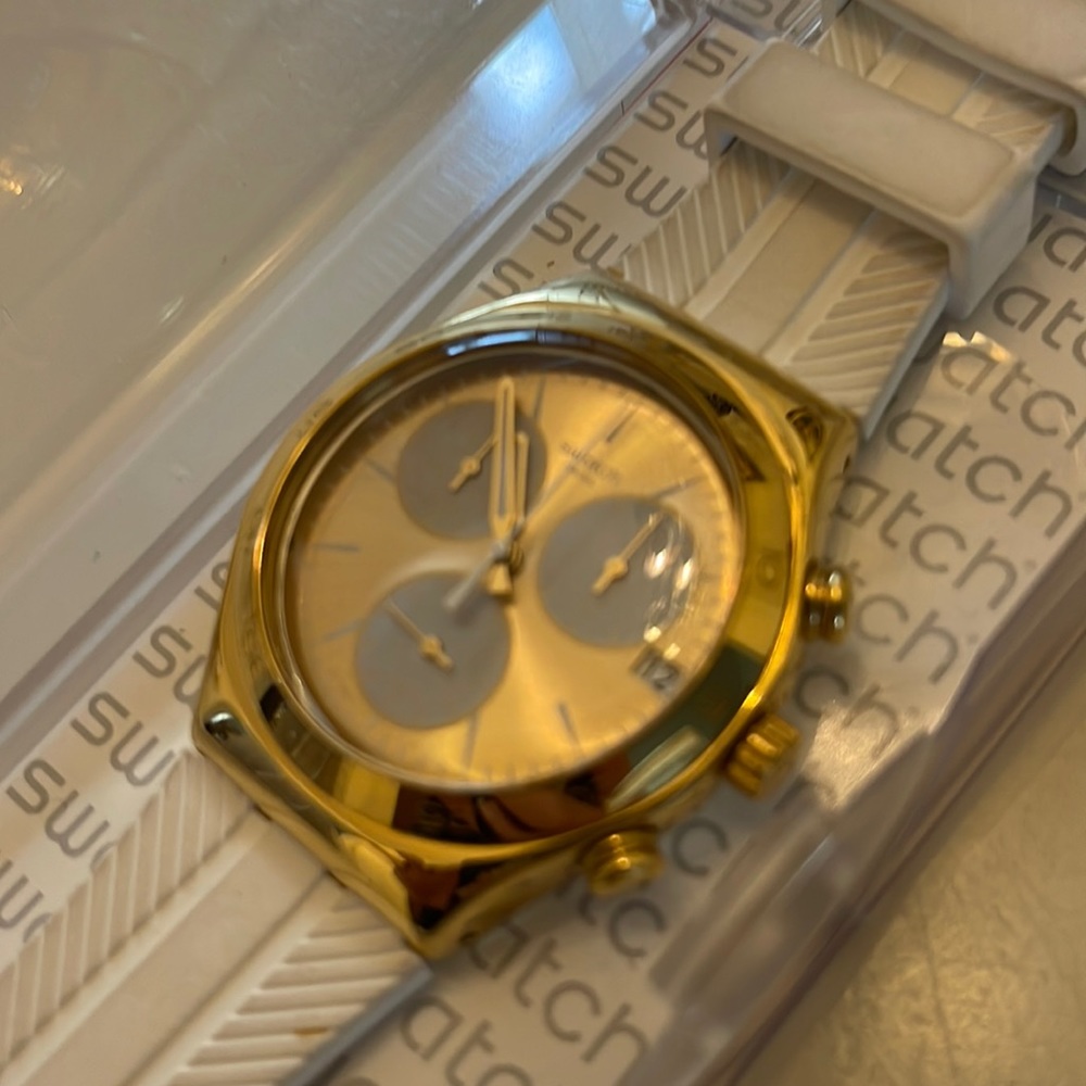 Swatch gold watch with plastic white band.